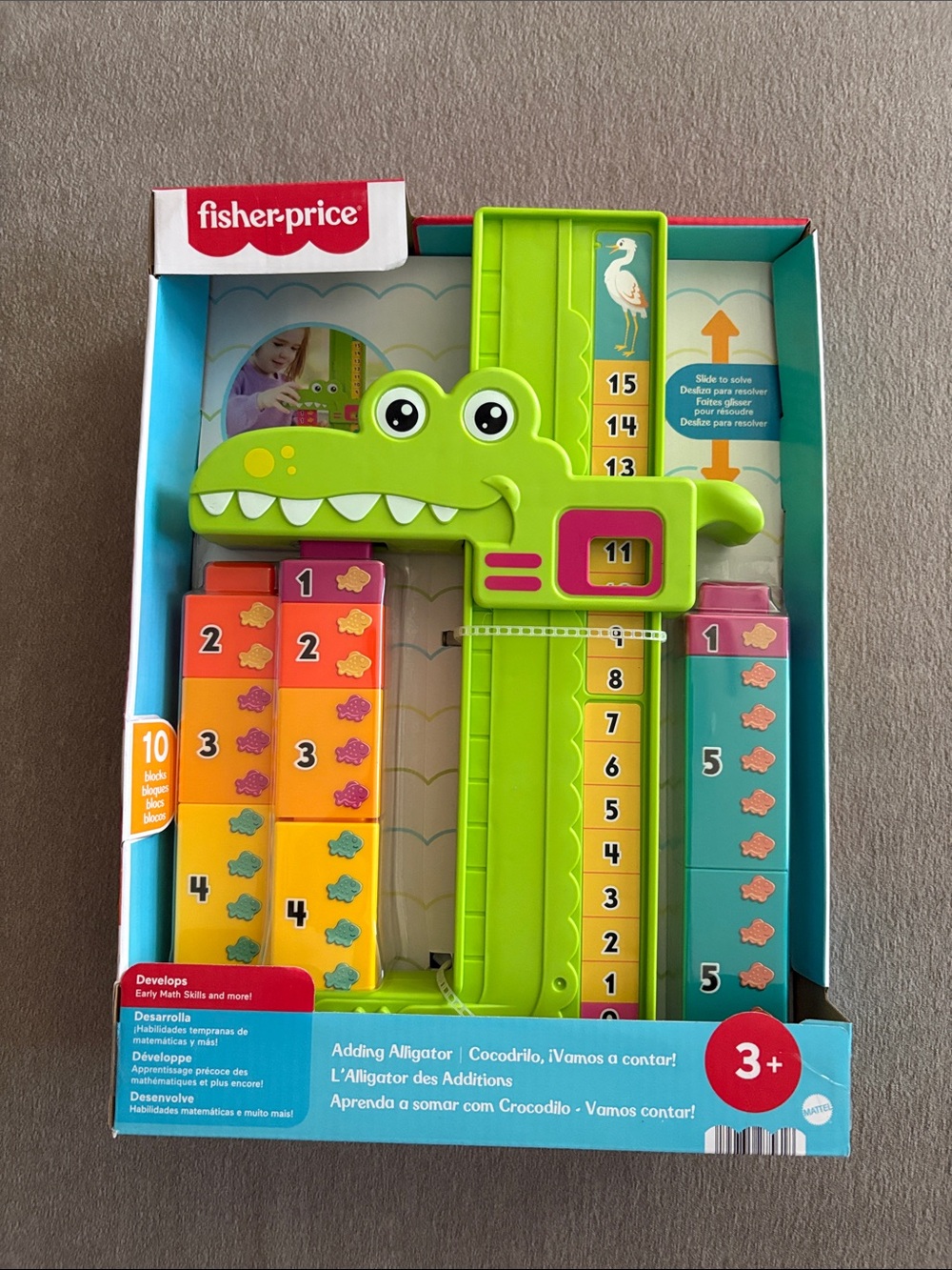 Fisher-Price green alligator counting toy with orange yellow pink teal blocks